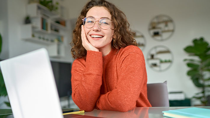 Zu sehen ist eine Teilnehmerin in ihrer Online-Weiterbildung, sie sitzt zu Hause an ihrem Arbeitsplatz.