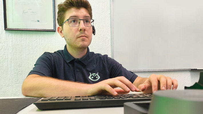 Zu sehen ist GFN-Absolvent Edin Huzejrovic an seinem Arbeitsplatz im eigenen IT-Unternehmen, der huzit GmbH.