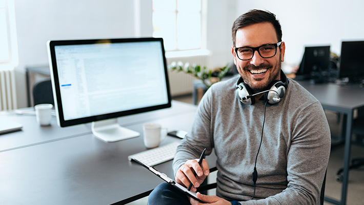 Ein IT-Supporter sitzt an seinem Arbeitsplatz und arbeitet seine Tickets durch.