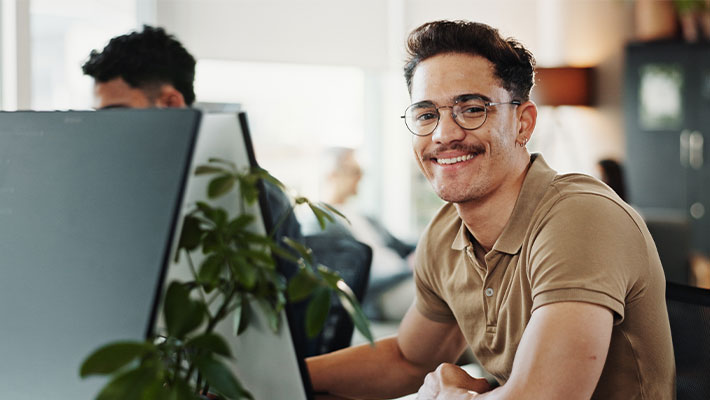 Ein Mitarbeiter nutzt KI-Anwendungen im Arbeitsalltag und wendet erlernte KI-Kompetenzen professionell an.